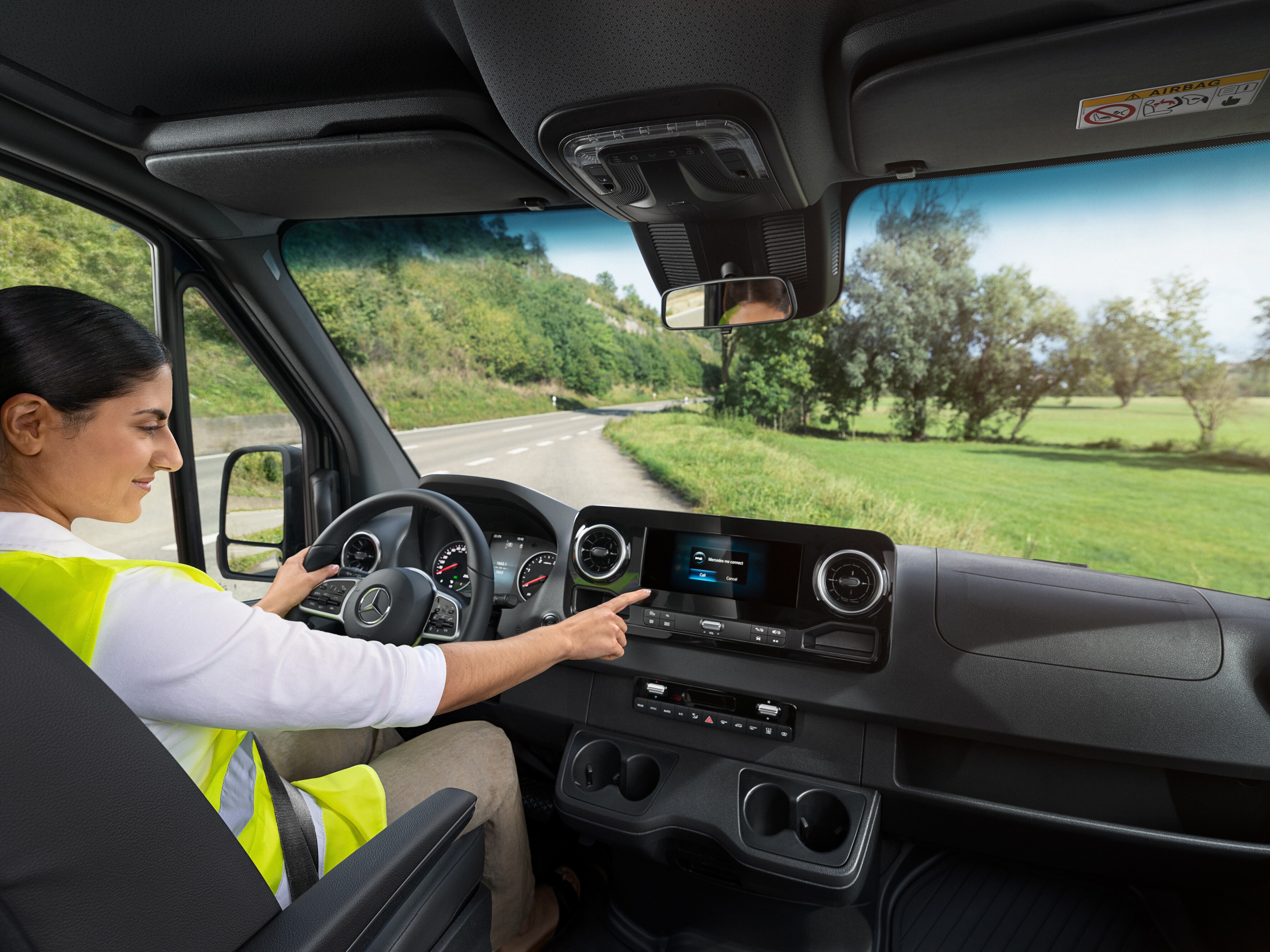 Bestuurster controleert display in haar Mercedes-Benz bedrijfswagen als onderdeel van MobiloVan service.