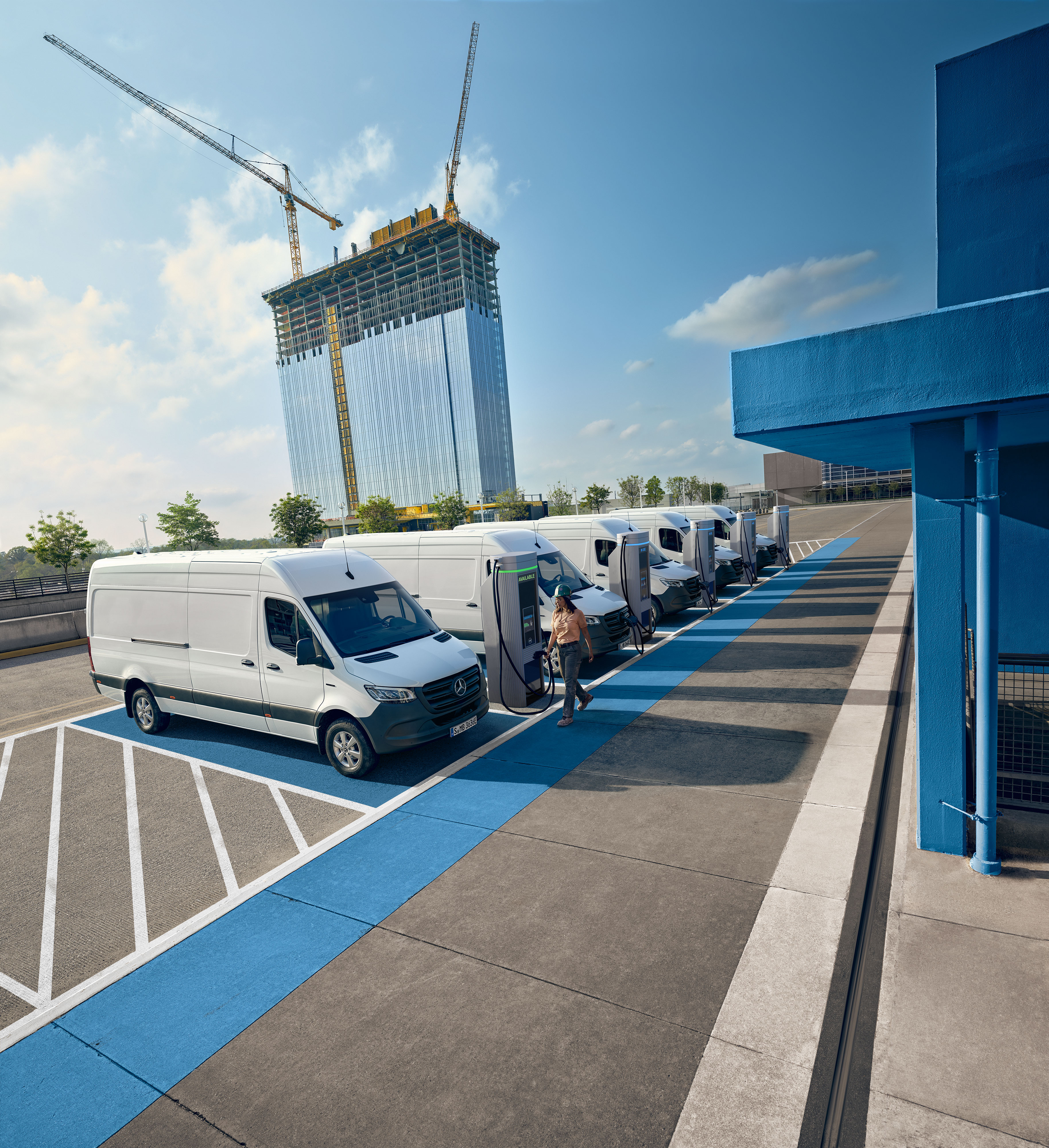Mercedes-Benz Comfort Een vloot witte elektrische Mercedes-Benz bedrijfswagens geparkeerd bij een laadstation.