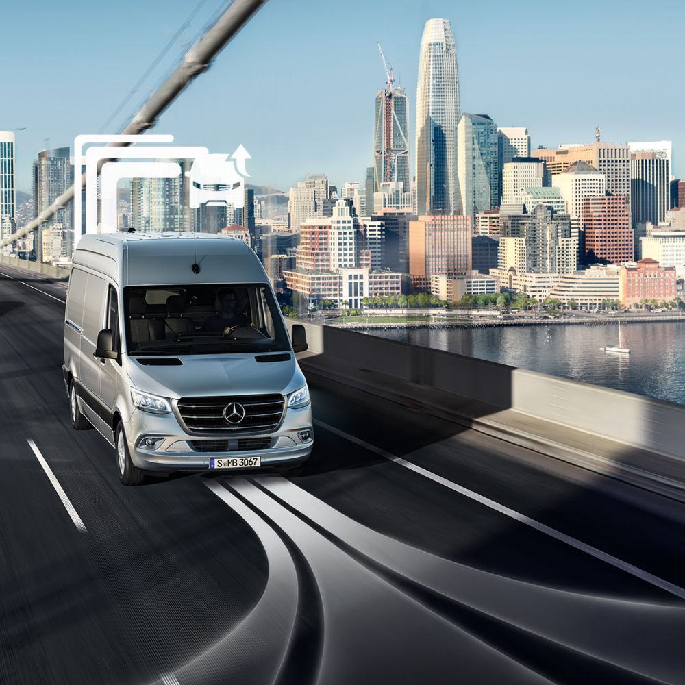 Voordelen Van Uptime Monitor | Digitale extra's | Mercedes-Benz Een Mercedes-Benz bestelwagen rijdt overdag over een brug met meerdere rijstroken.