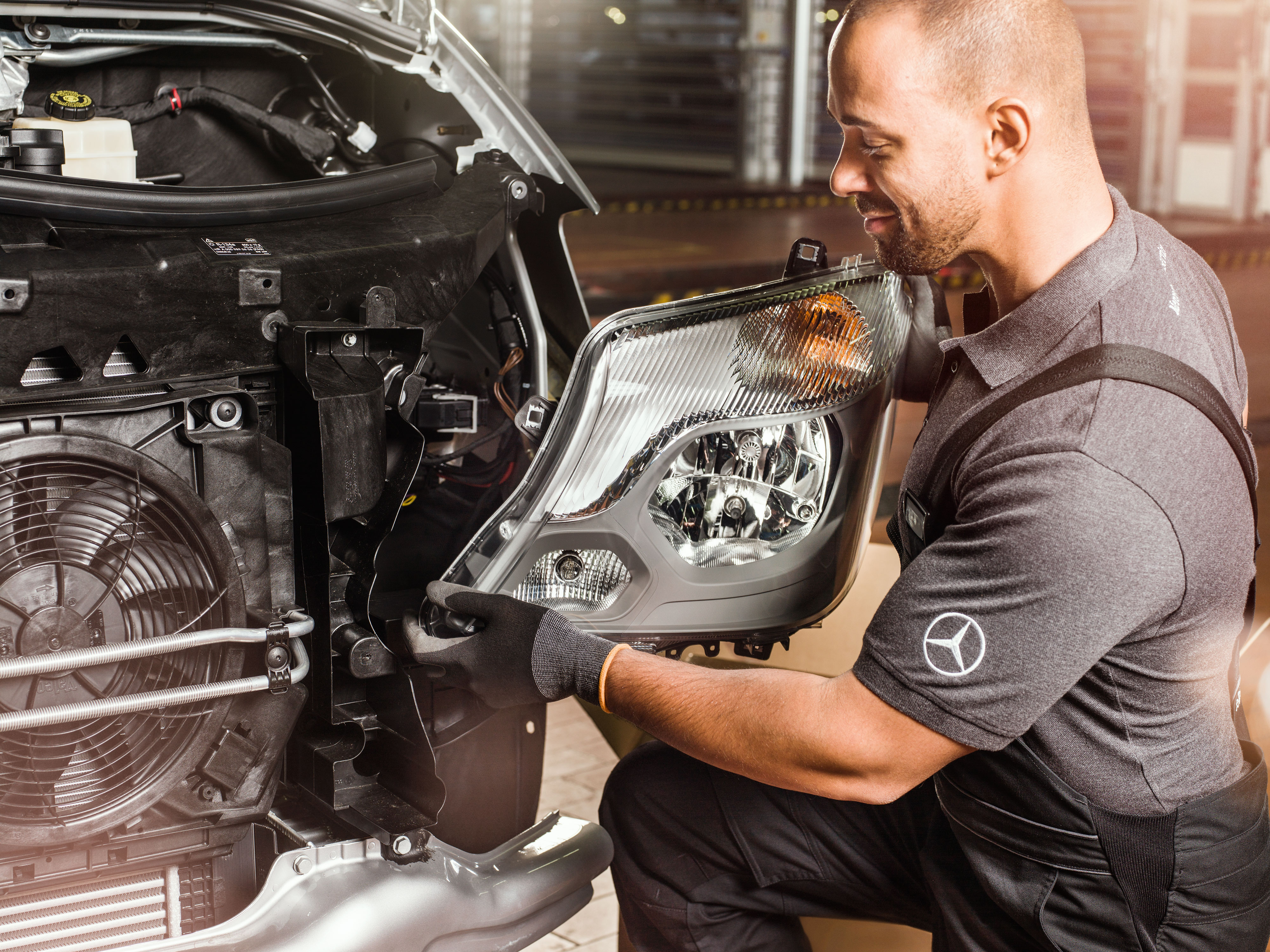 Mercedes-Benz Bedrijfswagen | Kwaliteit Originele Onderdelen Monteur controleert Mercedes-Benz Originele Onderdelen voor een open Sprinter-motor volgens de onderdelencatalogus.