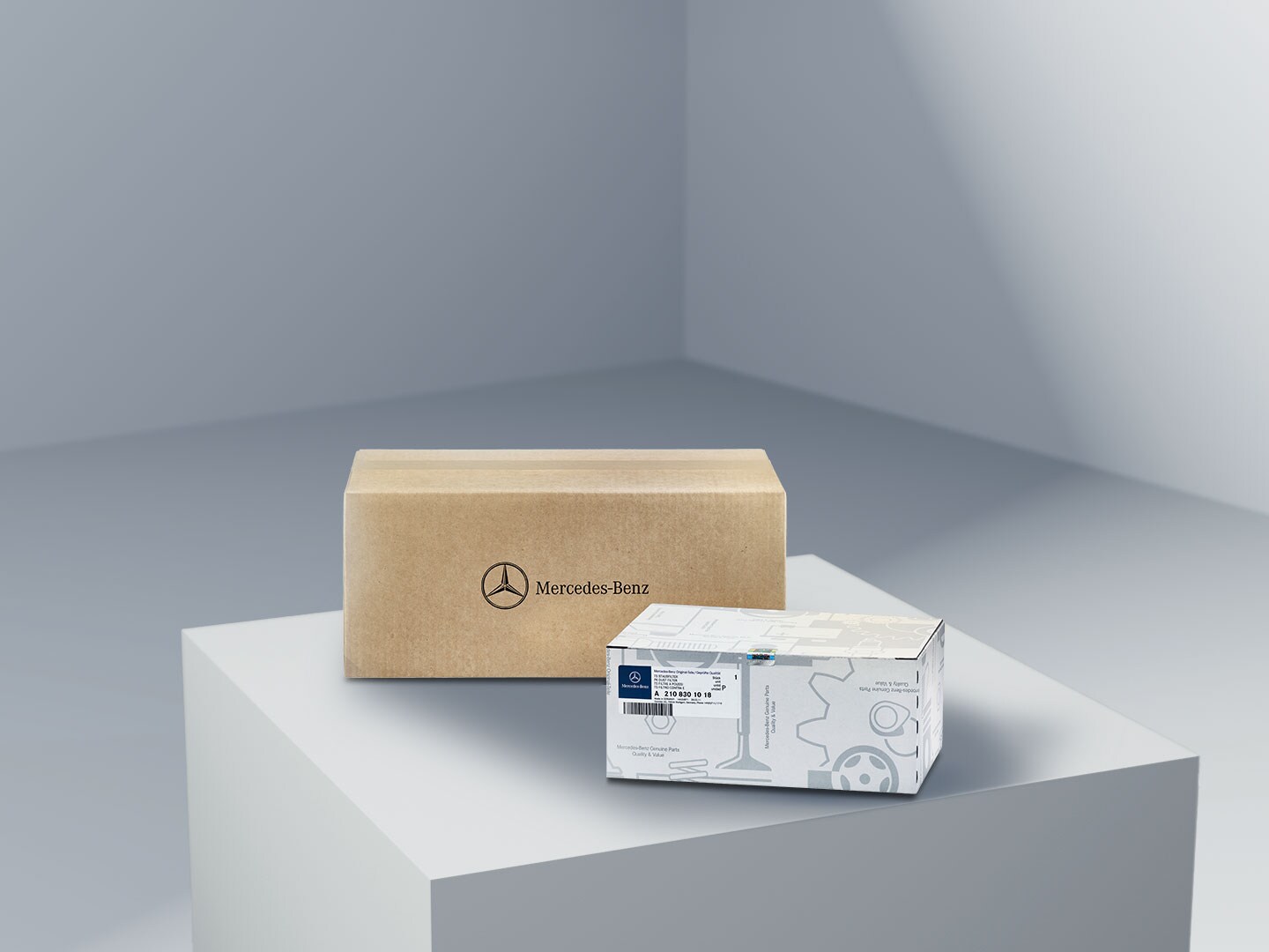 Deux paquets portant le logo Mercedes-Benz, symbolisant les pièces d'origine Mercedes-Benz, sur une plateforme de couleur claire.