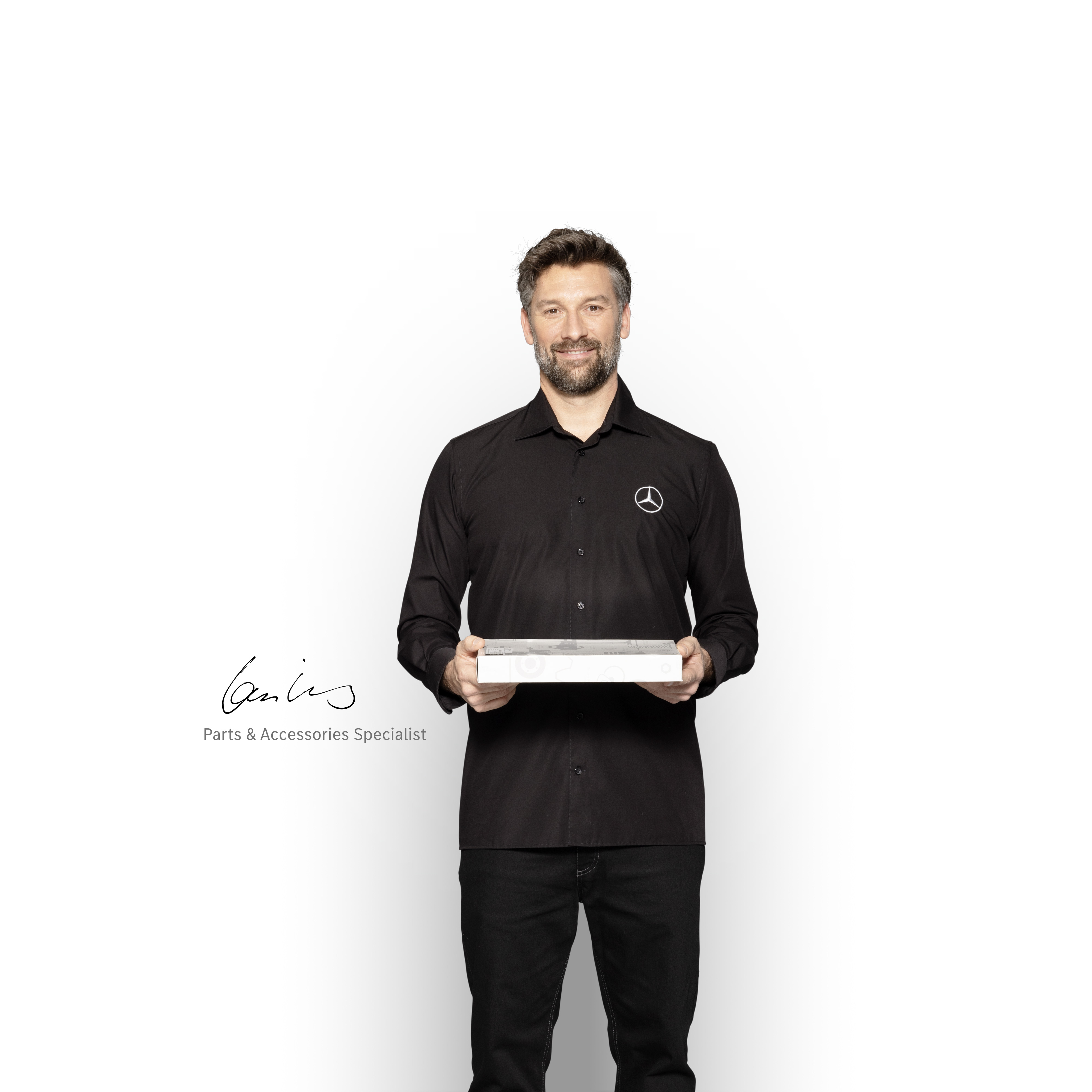 Mercedes-Benz | Pièces d'origine de qualité pour utilitaires légers Technicien interne Mercedes-Benz avec une boîte dans les mains pour montrer les pièces d'origine Mercedes-Benz.