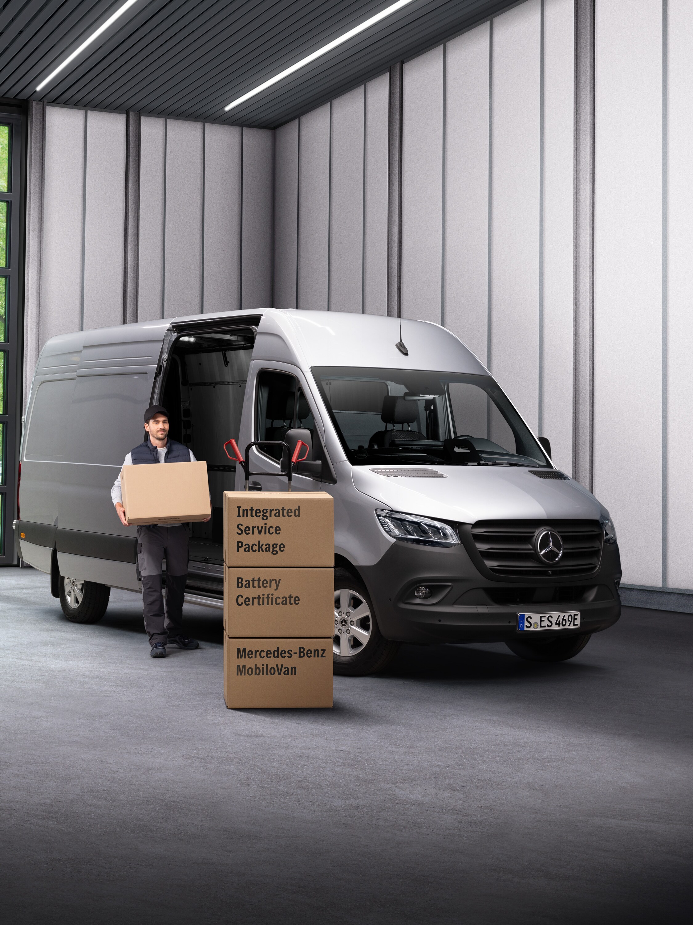 Een Mercedes-Benz servicemedewerker voor elektrische voertuigen die dozen uit een transport draagt