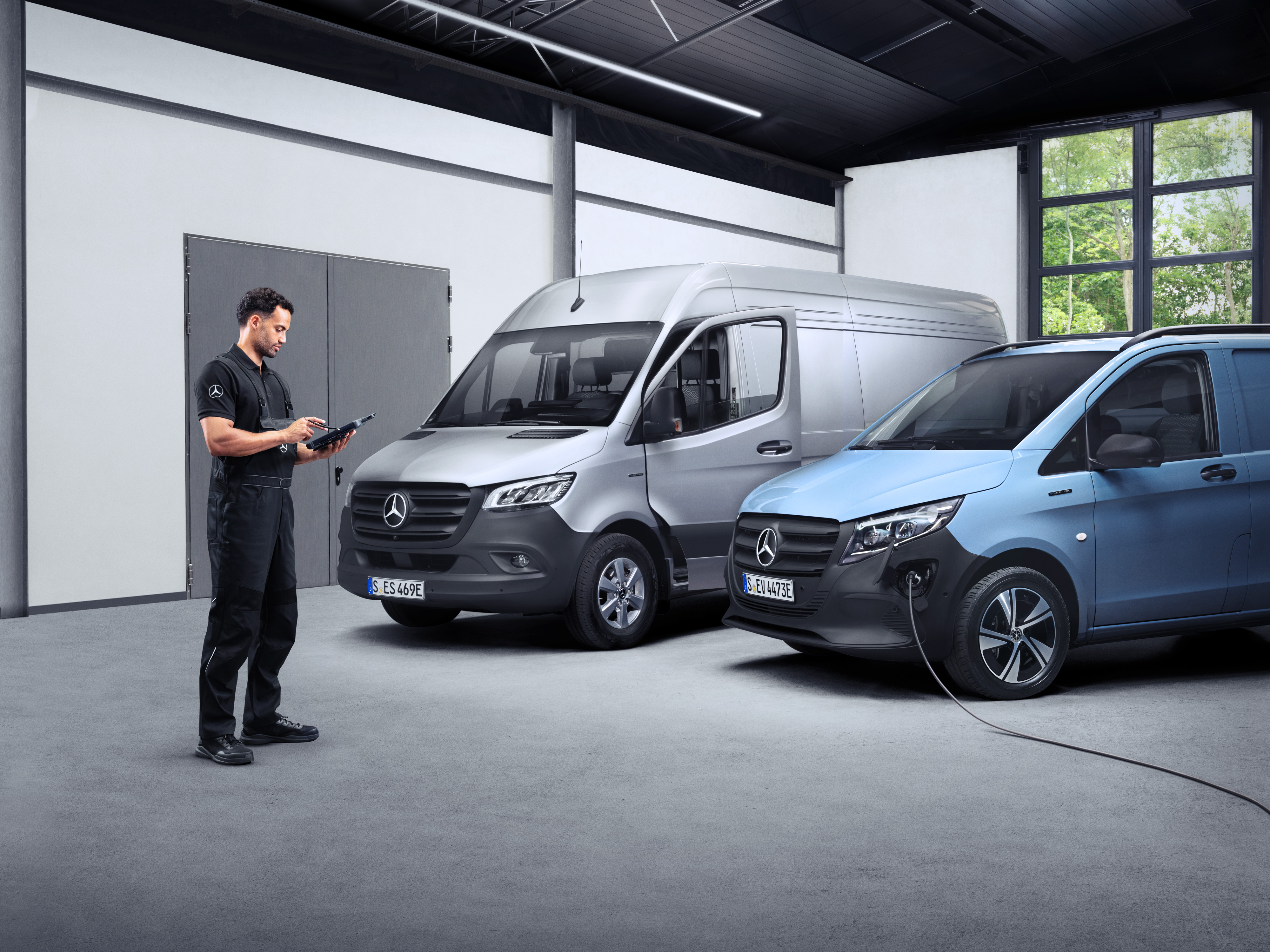 Mercedes-Benz | Bestelwagen ServiceCare Een technicus met een tablet voor twee eVans