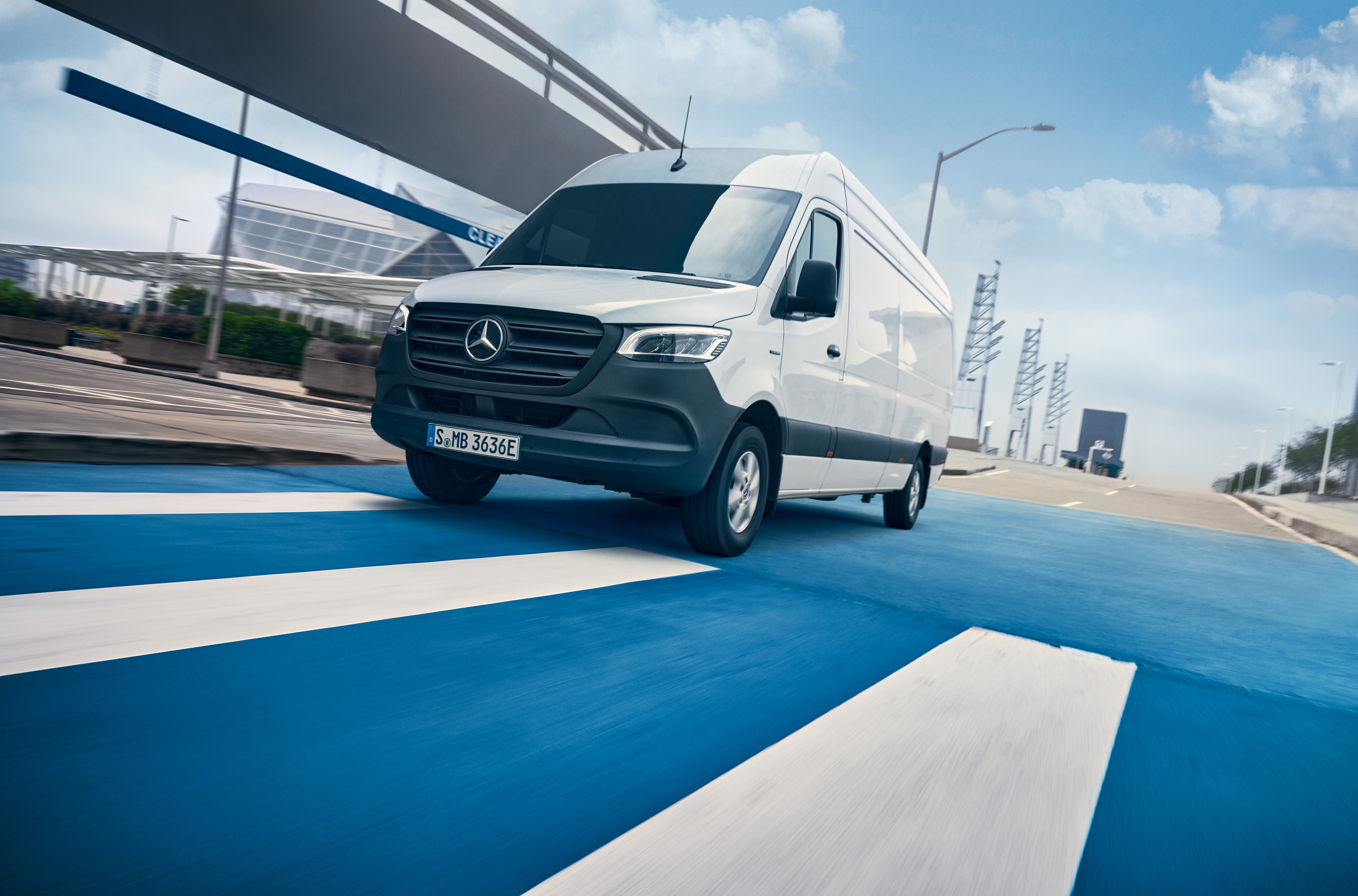 Mercedes-Benz | Van ServiceCare | Pack Pack Maintenance Une Mercedes-Benz Sprinter blanche roule sur une route dans une ville.