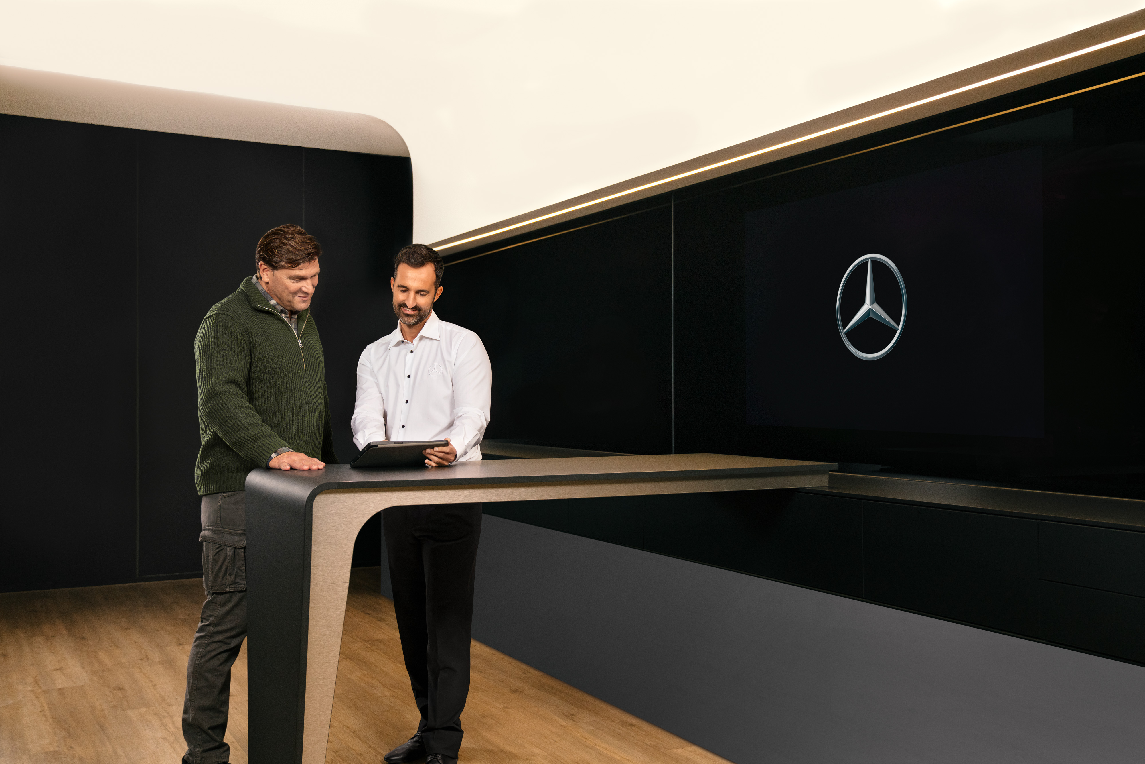 Mercedes-Benz | Servicesoverzicht | ServiceCare Twee mannen bespreken de bedrijfswagenservice van Mercedes-Benz via een tablet.