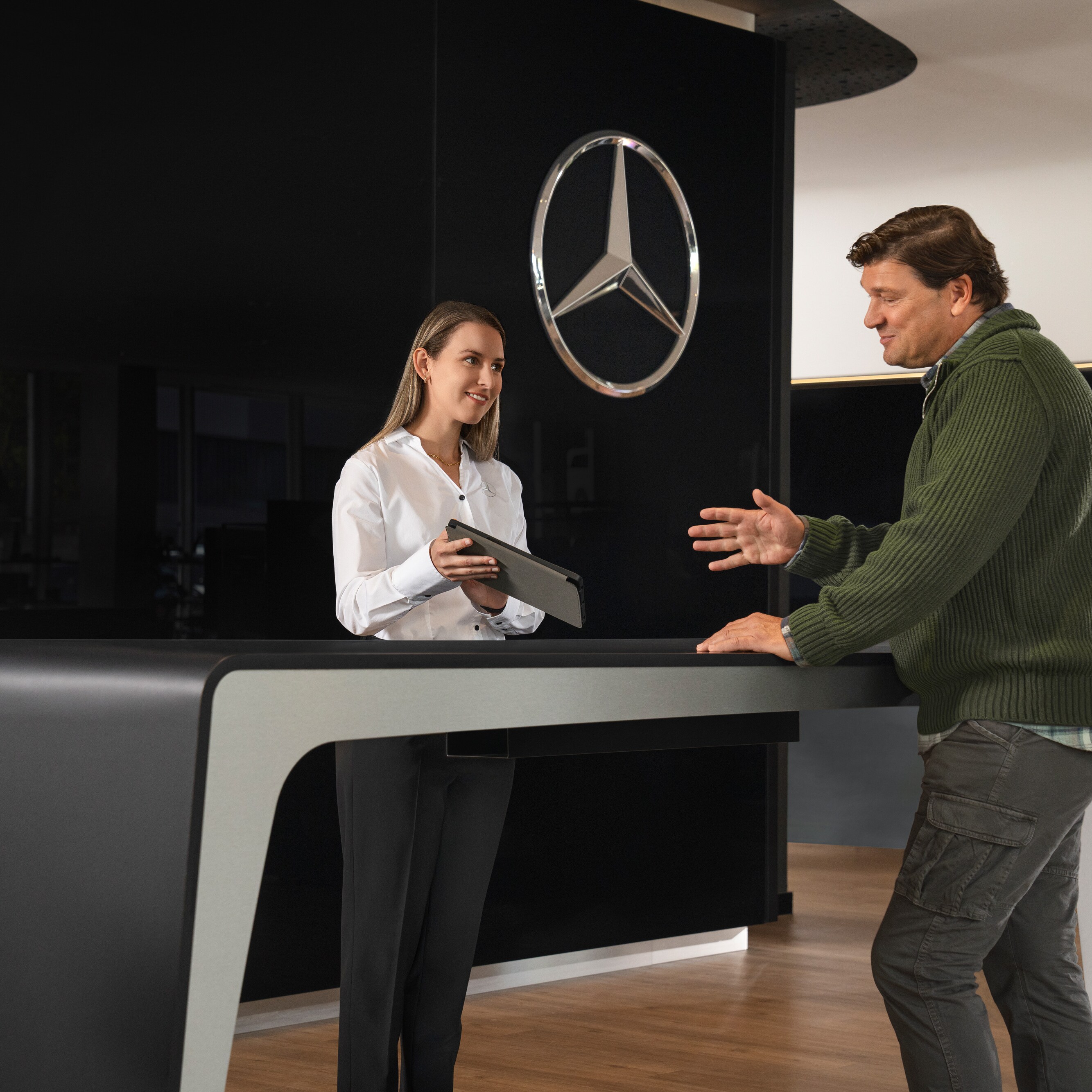 Mercedes-Benz adviseur geeft een klant persoonlijk advies over elektrische Bedrijfswagenservices.