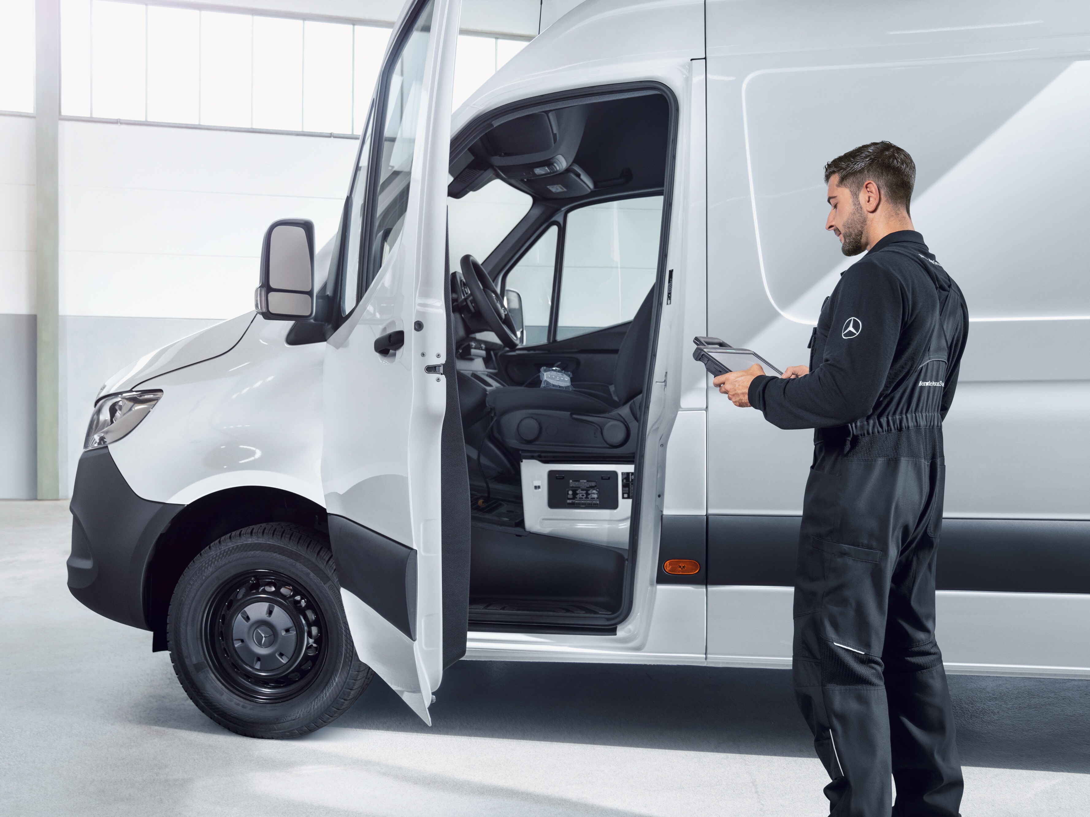 Medewerker inspecteert Mercedes-Benz Bedrijfswagen als symbool voor onderhoud en reparatie met betrouwbare servicekwaliteit.
