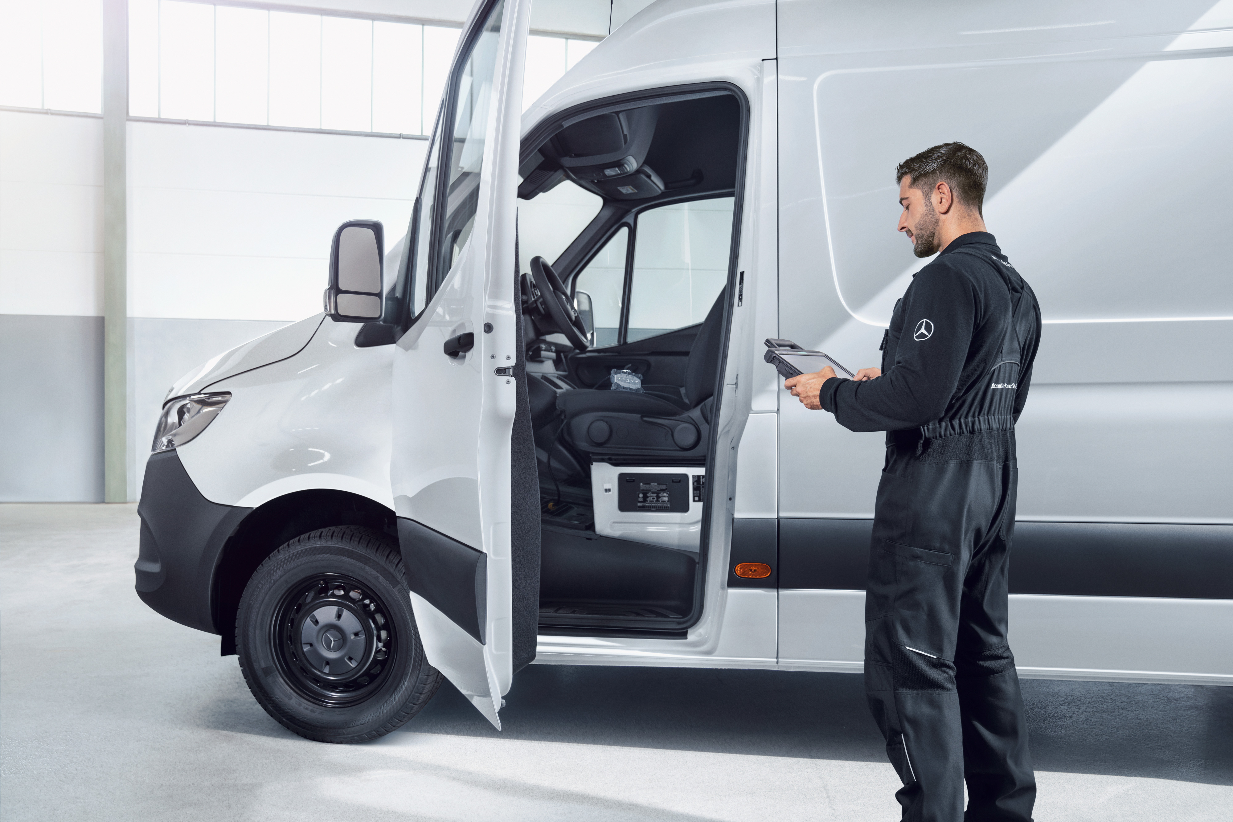Mercedes-Benz | Aperçu des services | Maintenance des véhicules Un employé inspecte un utilitaire léger Mercedes-Benz offrant une qualité de service fiable pour la maintenance et les réparations.
