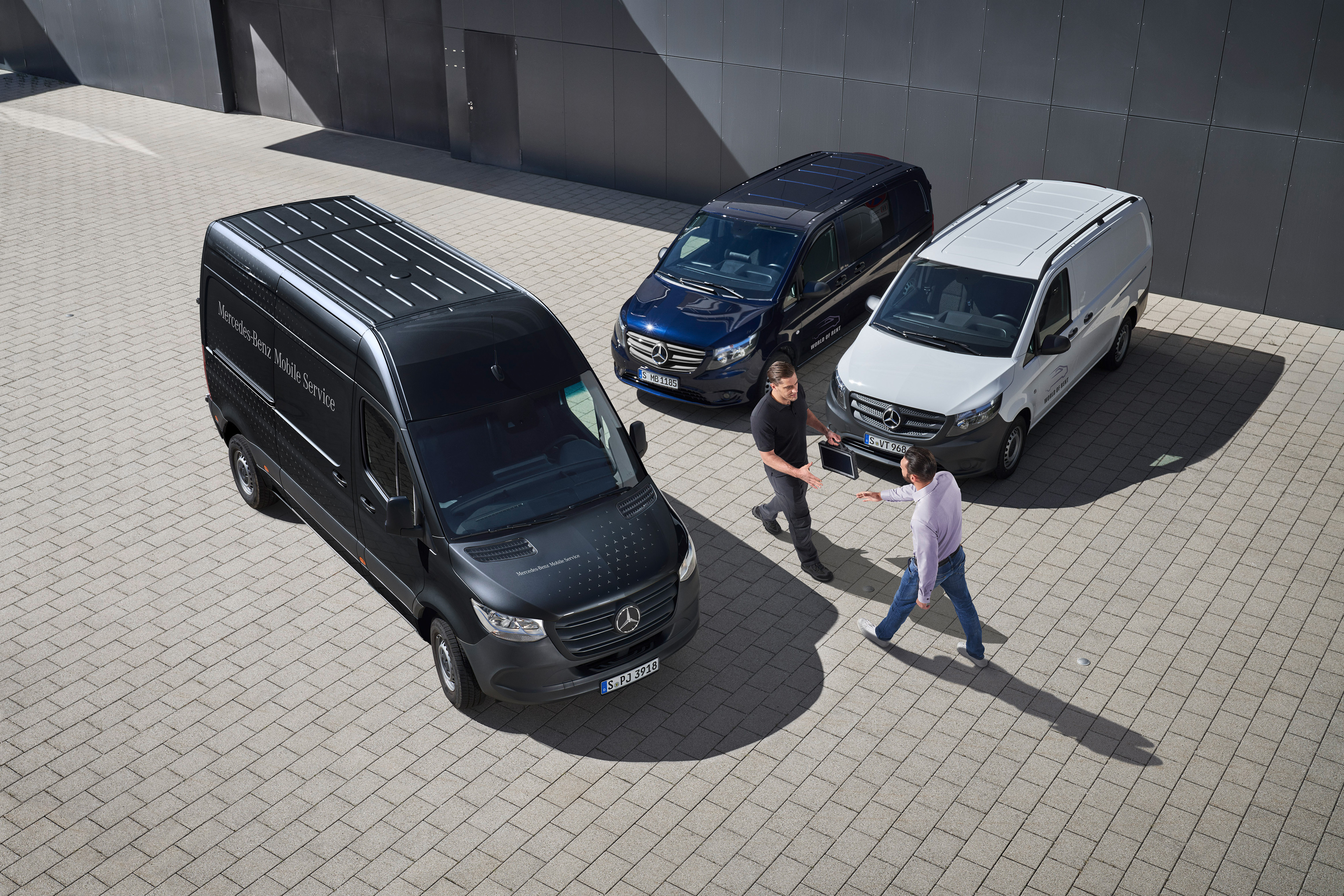 Mercedes-Benz | Servicesoverzicht | Mobiele Service Twee mannen begroeten elkaar tussen Mercedes-Benz bedrijfswagens.