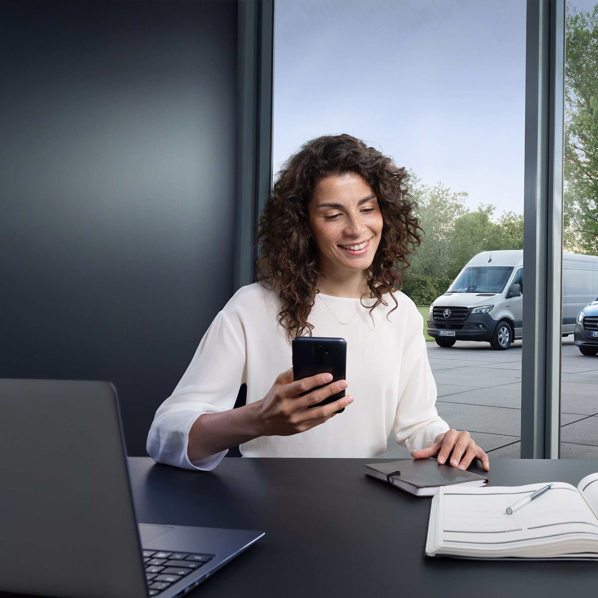 Een klant aan de telefoon voor een reeks Mercedes-Benz bedrijfswagens.