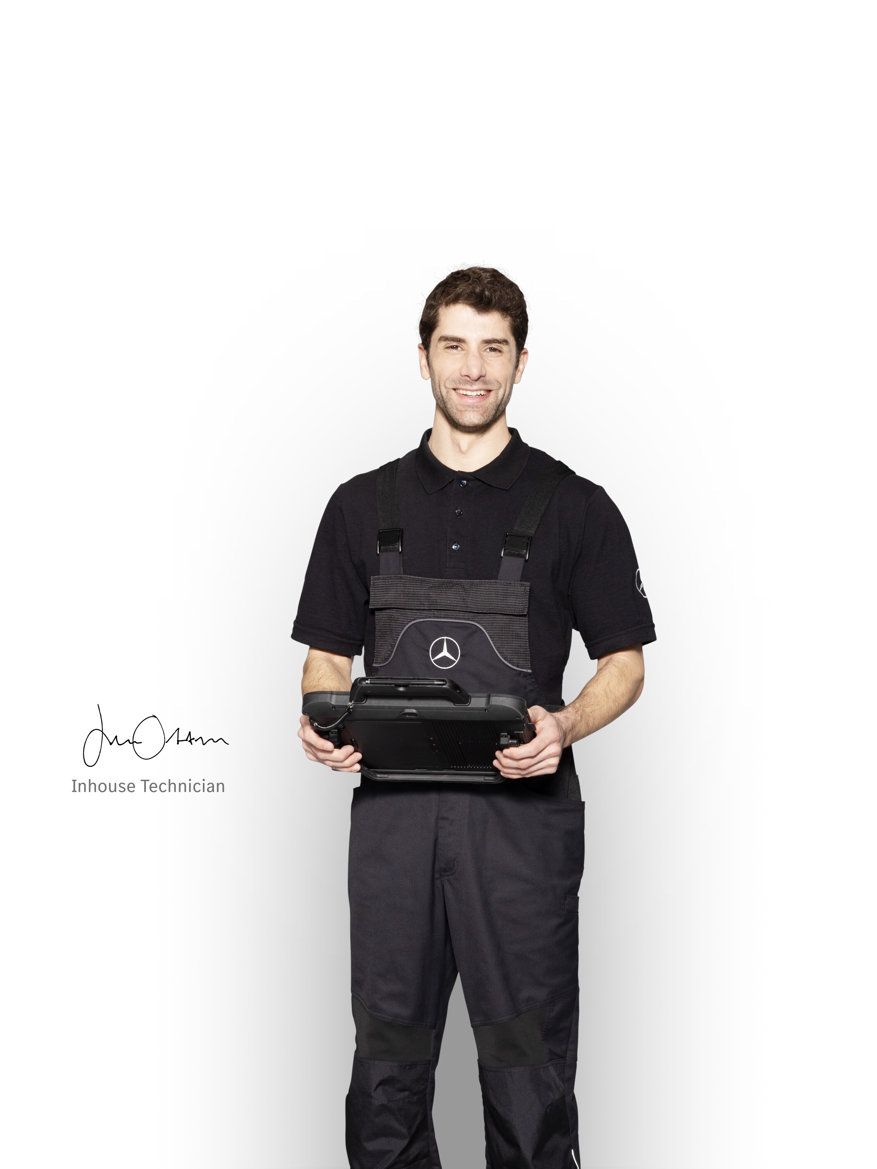 Mécanicien Mercedes-Benz en tenue de travail, tenant une tablette prête pour le signalement des dommages.
