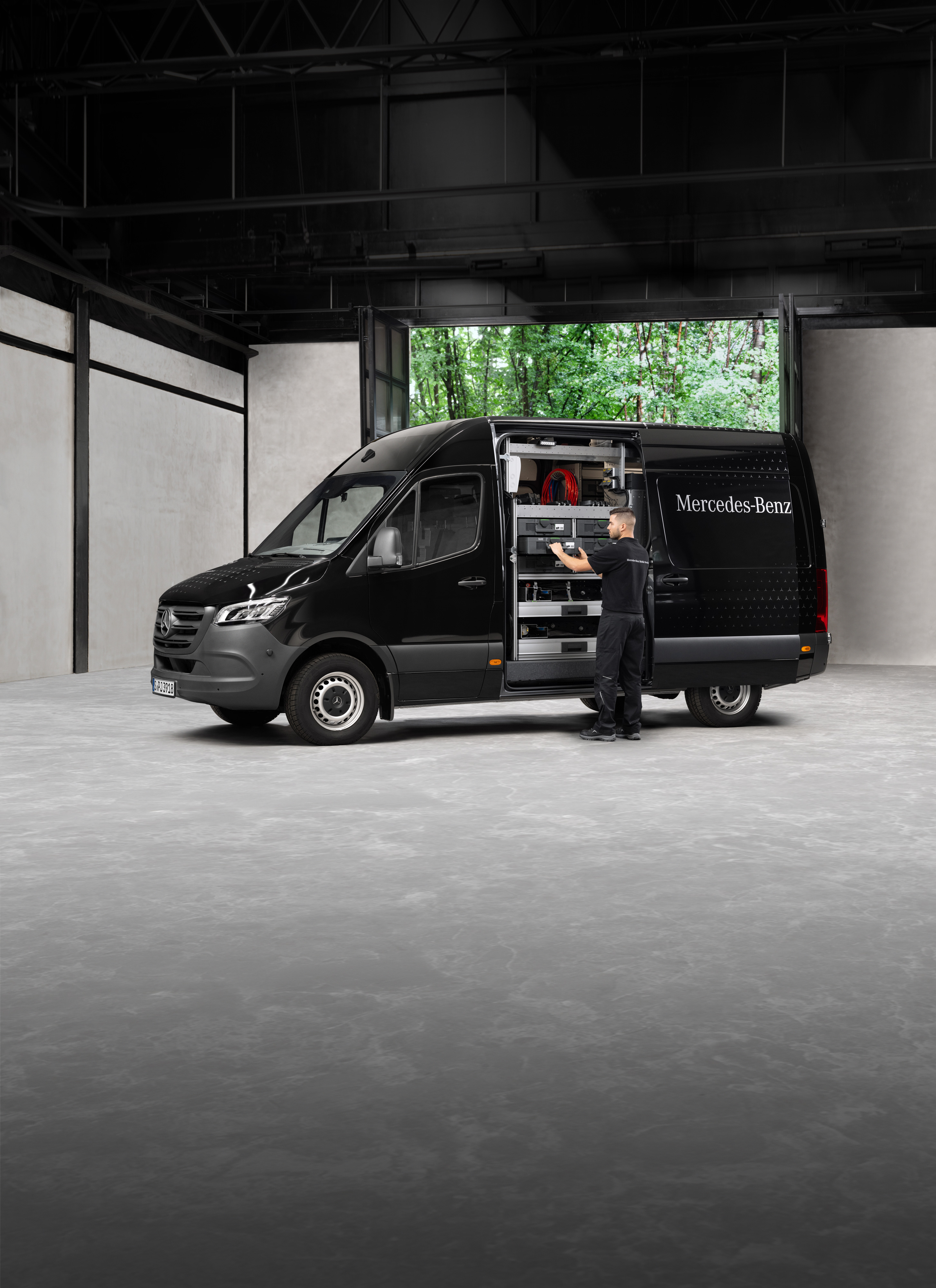 Mercedes-Benz | Service mobile | Contrôle saisonnier Un technicien retire les outils d'un utilitaire léger Mercedes-Benz Sprinter noir.