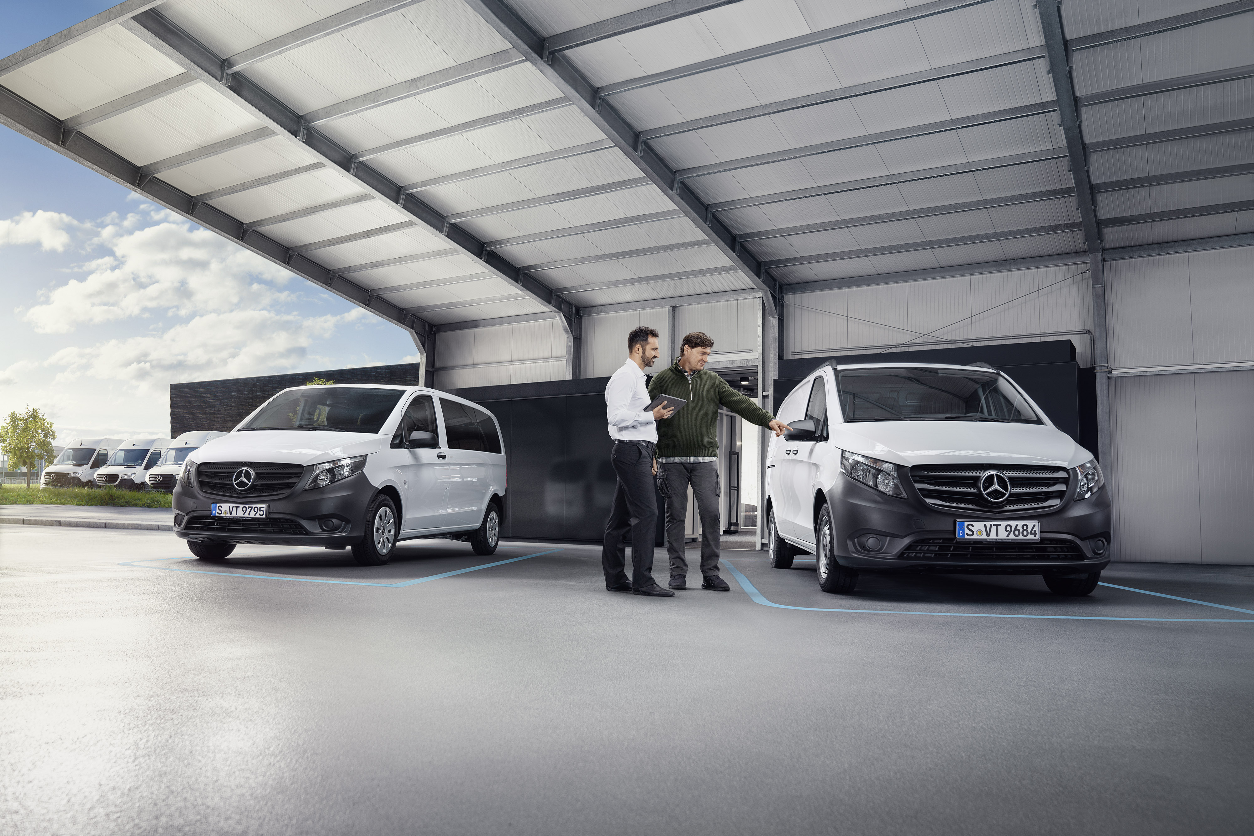 Réparation Mercedes-Benz | Rappel Agent SAV de Mercedes-Benz avec un client chez un partenaire de service devant un utilitaire léger.