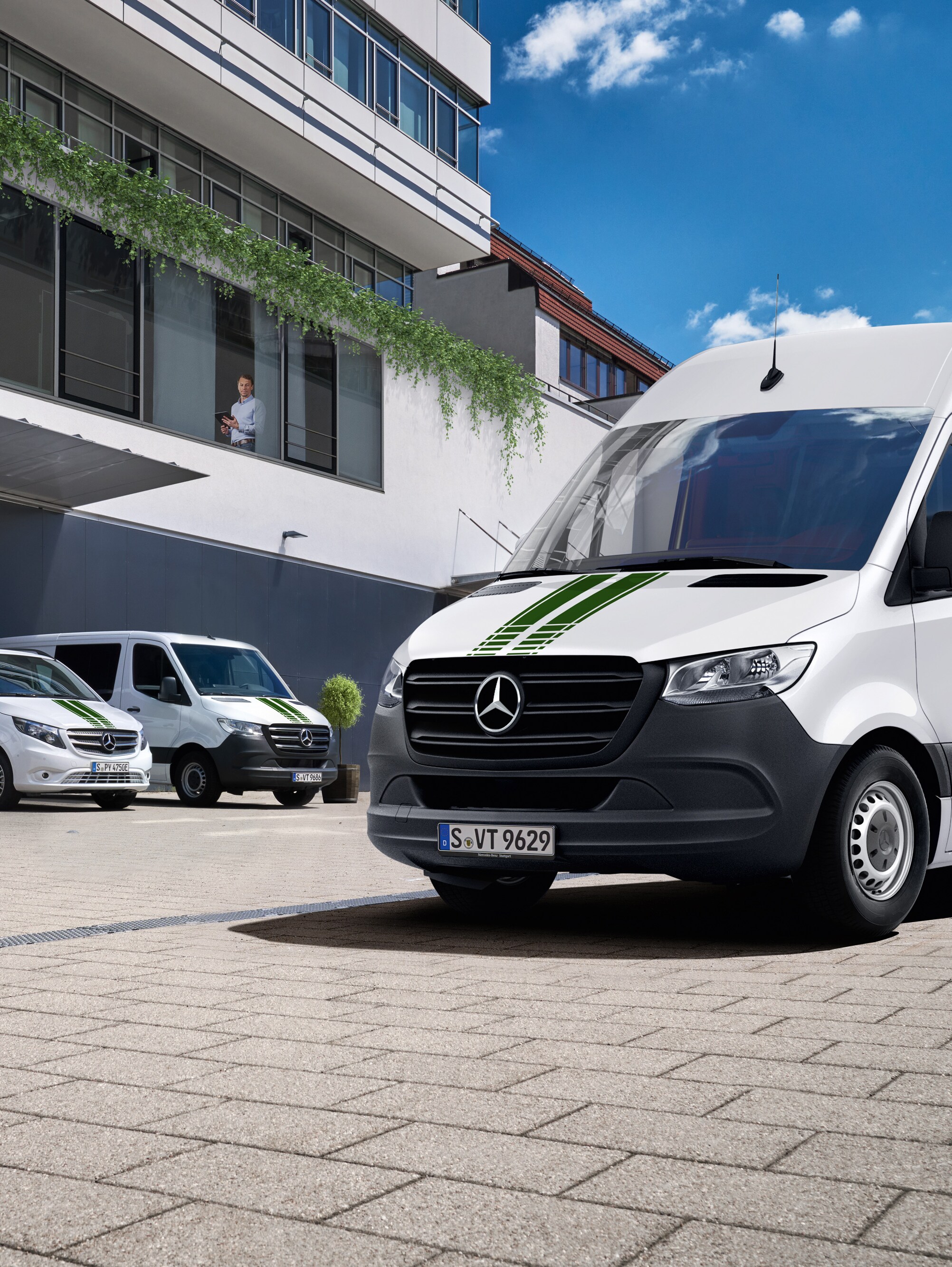 Een wagenpark Mercedes-Benz bedrijfswagens voor een gebouw, symbool voor digitale wagenparkcontrole.
