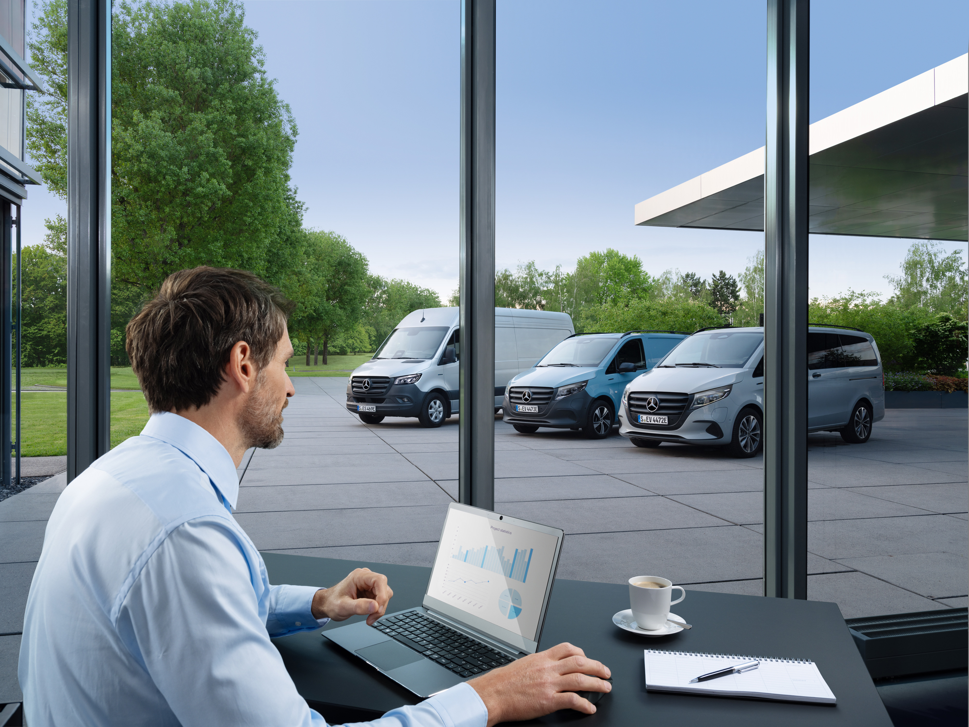 Mercedes-Benz Bedrijfswagentechnologie | Van Uptime Monitor Man met laptop bewaakt meerdere geparkeerde Mercedes-Benz Bedrijfswagens als symbool voor digitaal vlootbeheer.