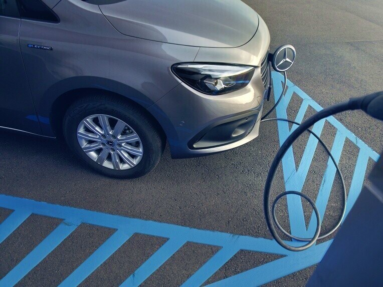 De Mercedes-Benz eCitan Tourer wordt opgeladen bij een laadpunt.