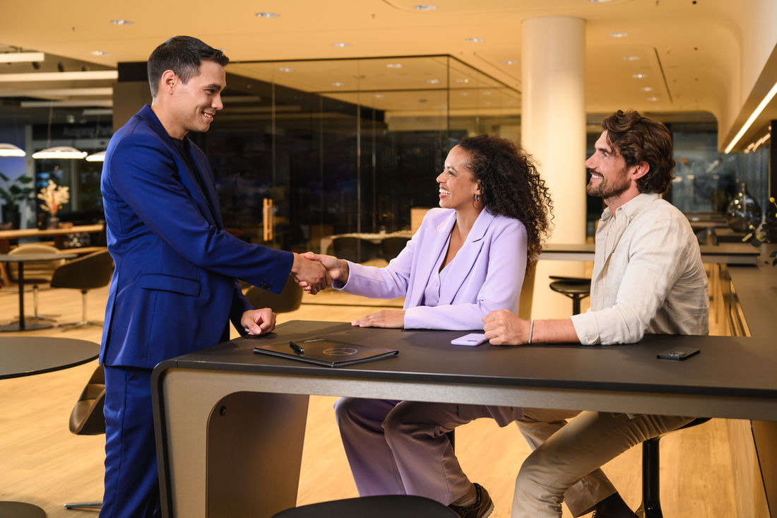 Poignée de main après l’achat réussi d’un véhicule utilitaire. Un conseiller commercial et un client se serrent la main après la finalisation d’un contrat pour un véhicule utilitaire.
