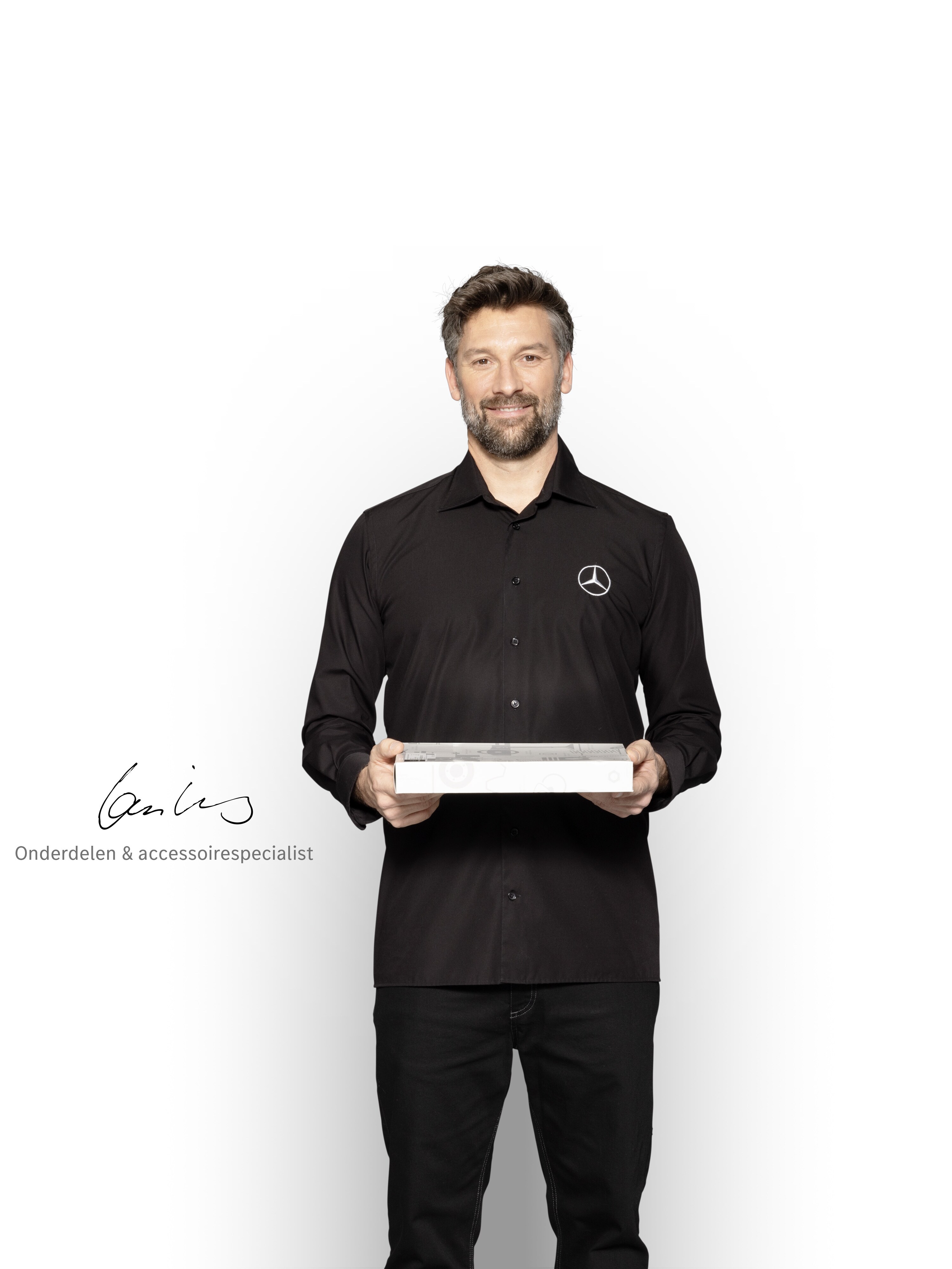 Mercedes-Benz monteur met een doos in zijn handen om Mercedes-Benz originele onderdelen te tonen.